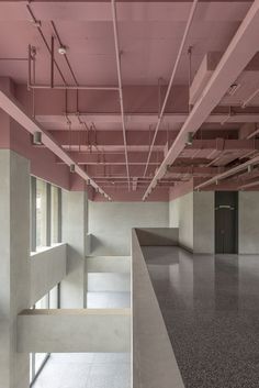 an empty room with concrete floors and pink paint on the ceiling is seen in this image