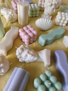 there are many different types of soaps on the table, including candles and figurines