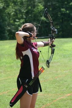 a young woman is practicing her archery skills