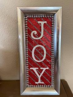 a red and silver frame with the word joy on it