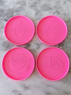 four pink plates with coffee designs on them