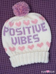 a knitted hat with the words positive vibes written in purple and pink hearts