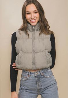 This cropped, padded puffer vest in a neutral shade features a high neckline with a zip-up front. Perfect for layering, this vest offers both warmth and style. Fall Outfits School, Next In Fashion, 2025 Fashion Trends, Fashion Landscape, Style Essentials, High Neck Designs, Peacoats, Biker Jackets, 2025 Fashion