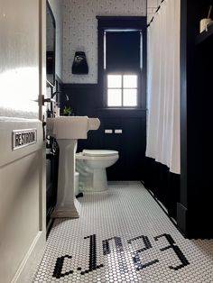 a black and white bathroom with the word toilet spelled out on the floor in large letters