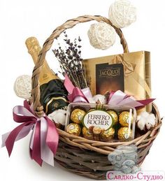 a basket filled with lots of chocolates next to a teddy bear and other items