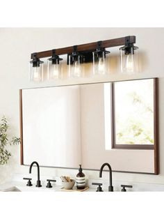 a bathroom vanity with three lights and a mirror