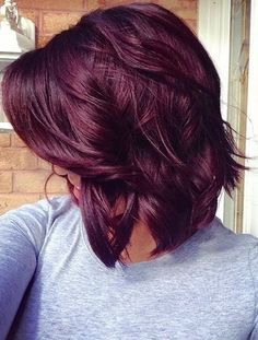 the back of a woman's head with red hair in front of a brick wall