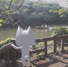 a white cat standing on top of a wooden fence next to a body of water