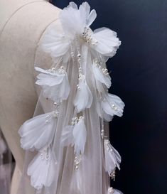 the back of a dress with white feathers and pearls