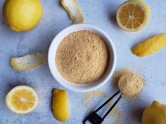 a bowl filled with powder next to sliced lemons and other ingredients on a table