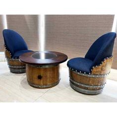 two chairs and a table made out of wooden barrels with metal studs on them