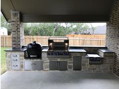 an outdoor kitchen with stainless steel appliances and cabinets