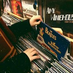 a person is playing an organ in a music store with vinyl records on the shelves