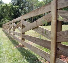 a wooden fence with grass growing through it