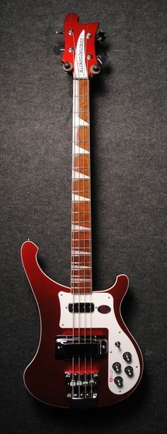 a red electric guitar sitting on top of a black surface