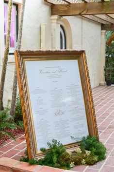 a large framed menu sitting on top of a brick walkway