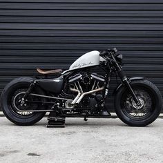 a black and white motorcycle parked in front of a garage door