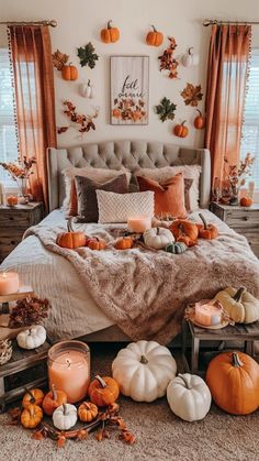 a bedroom with pumpkins and candles on the bed