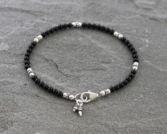 3mm Black Onyx beads are paired with sterling silver accents in this dainty bracelet. Finished with a secure sterling silver lobster clasp and coordinating sterling silver charms. Perfect to wear by itself or with other bracelets for a stacked look. Sterling silver is .925 pure silver. ✧ Message me if you would like this bracelet in a different size. See more Onyx jewelry here: https://www.etsy.com/shop/LindseySilberman?ref=l2-shopheader-name&search_query=onyx Check out other items in my sho Black Bead Bracelet Ideas, Black Bracelet Ideas, Black Beads Earrings, Black Silver Bracelet, Baby Jewelry Gold, Silver Bracelet Designs, Gelang Manik-manik, Anklet Designs, Black Onyx Bracelet