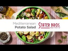 a green bowl filled with potato salad next to other foods and vegetables on a pink table cloth