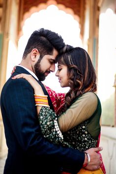 a man and woman embracing each other in front of a building