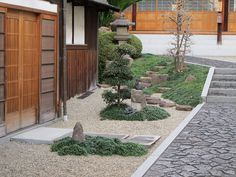 a small garden with rocks and trees in the center, surrounded by graveled walkways