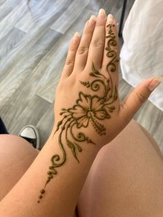 a woman's hand with henna tattoos on it