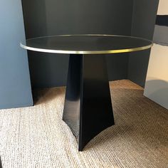 a round glass table sitting on top of a carpeted floor next to a wall