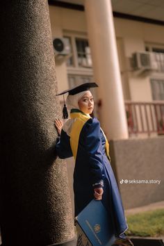 a woman in graduation gown leaning against a column