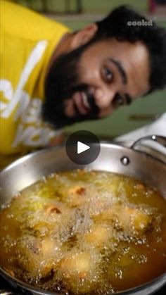 a man standing next to a pan filled with food