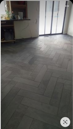 an empty room with wood flooring and glass doors leading to the outside patio area