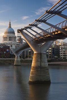 a bridge that is over water with buildings in the background