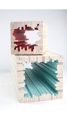 two pieces of wood are stacked on top of each other, with red and blue strips sticking out of them