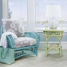 a living room with two chairs and a table in front of a window that looks out onto the water