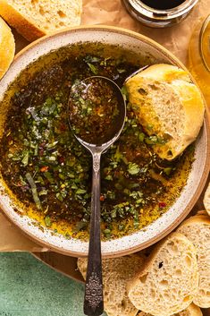 a bowl filled with soup next to slices of bread