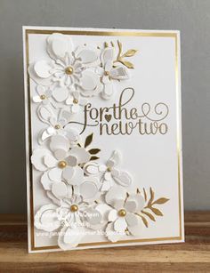 a card with white flowers and gold foil