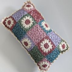 a crocheted pillow with flowers on it