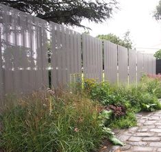 a brick path leads to a garden with tall grass and flowers