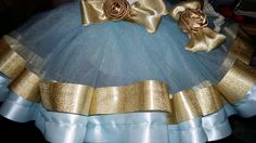 a blue and gold dress with bows on it