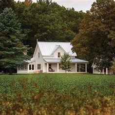 a large white house sitting in the middle of a lush green field