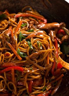 stir fry noodles with chicken and vegetables in a wok