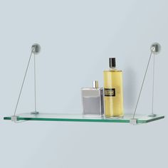 a shelf with two perfume bottles and one cologne bottle on it, hanging from the ceiling