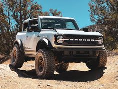 a white truck driving down a dirt road