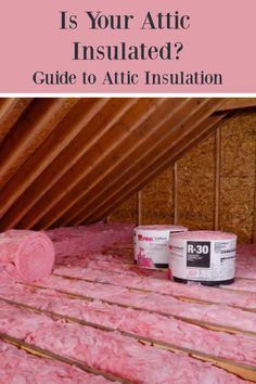 an attic with insulation in it and two pink cans on the floor next to it