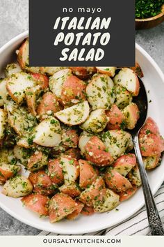 a white bowl filled with potatoes covered in pesto sauce and topped with parsley