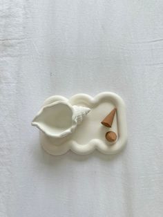 a toothbrush holder that is shaped like a shell and has a wooden spoon in it