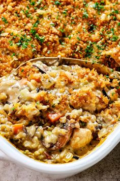 a casserole dish with meat and vegetables in it, topped with parsley