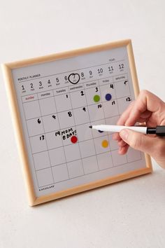 a person writing on a calendar with a marker