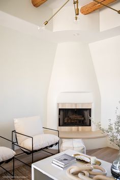 a living room with white furniture and a fireplace