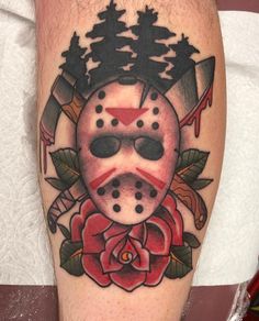 a tattoo with a mask and roses on it